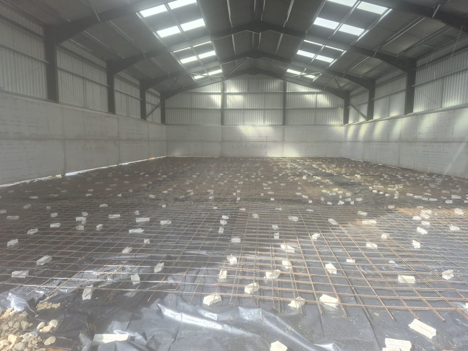 Before: DPM and steel mesh on spacers across a barn floor